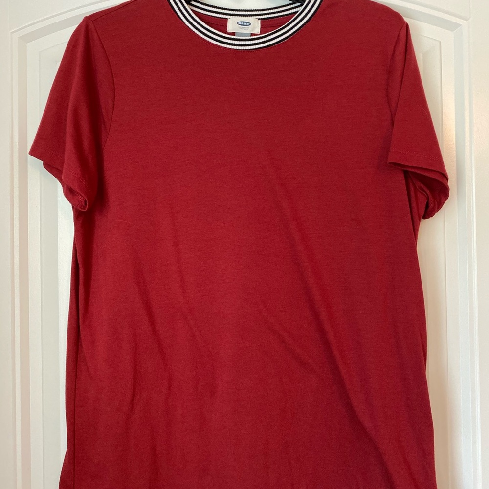 A red shirt with a blue and white striped neck